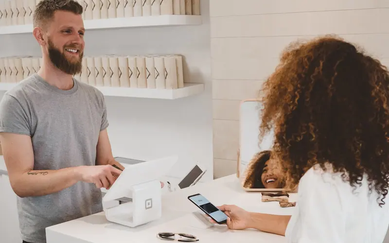 Customer paying by card at a retail counter
